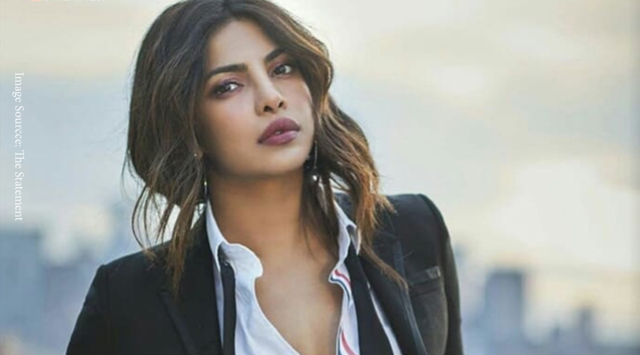 Priyanka Chopra posing in white shirt, black jacket and loose bun.