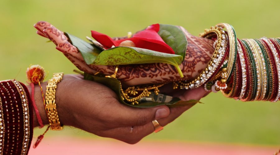 BRIDE AND GROOM'S HAND GOLDING BEATLE LEAF AS INDIAN WEDDING TRADITIONS